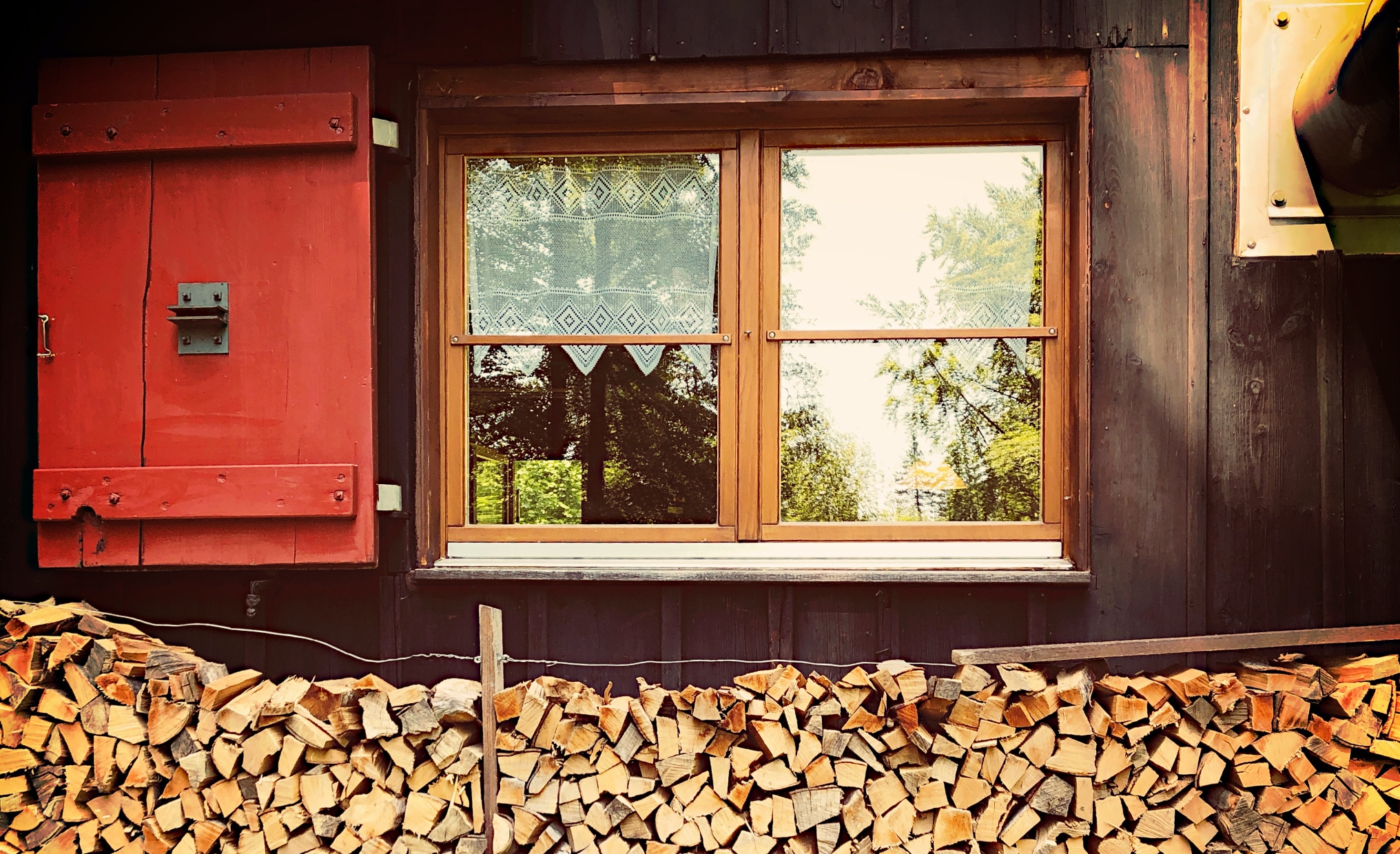 Fenster mit Feuerholz davor
